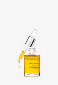 Przezroczysta szklana butelka z zakraplaczem i srebrną nakrętką. Zawiera żółty serum oznaczone "Sérum Phytarosa" w czarnym tekście. Pojemność: 30 ml.