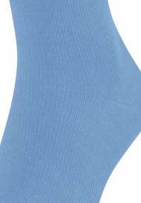 Helehelesin sinine sokk, millel on sooniktextuur, sile viimistlus ja kuju, mis on loodud mugavaks sobitamiseks jalga.