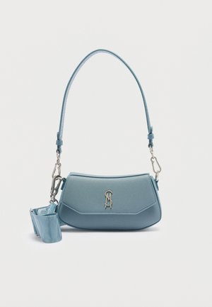 Hellblaue Lederhandtasche mit einem einzelnen, gebogenen Tragegriff, silbernem Logo-Emblem auf der Vorderseite und abnehmbarem breitem Stoffriemen, der an der Seite befestigt ist.