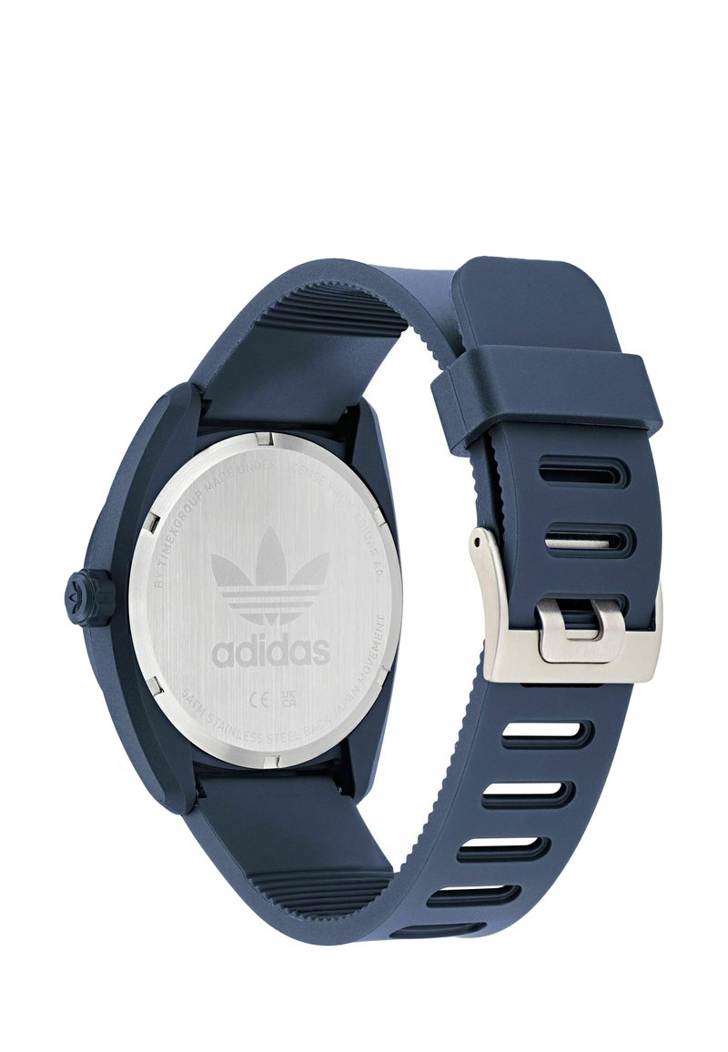 Adidas sports watch with dark blue silicone strap, stainless steel back, and silver buckle, showing the watch's rear side.