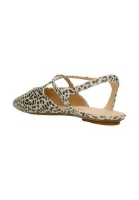 Chaussure plate à bout pointu, fabriquée en matériau beige avec un imprimé léopard noir. Présente des bretelles croisées et un design minimaliste à l'arrière.