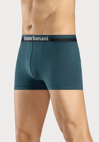 Teal boxershorts met een zwarte tailleband met de merknaam "bruno banani." Gemaakt van een zachte, elastische stof met een aansluitend ontwerp.