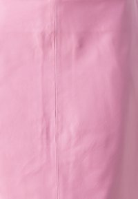 Falda de cuero rosa con una textura suave y líneas limpias, con una costura central. El material tiene un ligero brillo y un acabado suave.