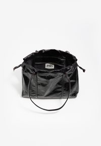 Czarna, błyszcząca skórzana torba tote z dwoma uchwytami, otwarte dno odsłaniające wewnętrzną metkę "Bimba Y Lola" oraz wewnętrzną kieszeń na zamek.