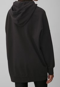 Hoodie noir surdimensionné en coton doux mélangé, avec une grande capuche, des épaules tombantes et des poignets et un ourlet côtelés.