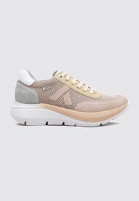 Zapatilla con parte superior de malla en beige y gris, con un acento amarillo y un talón blanco. Suela blanca gruesa con detalles texturizados.