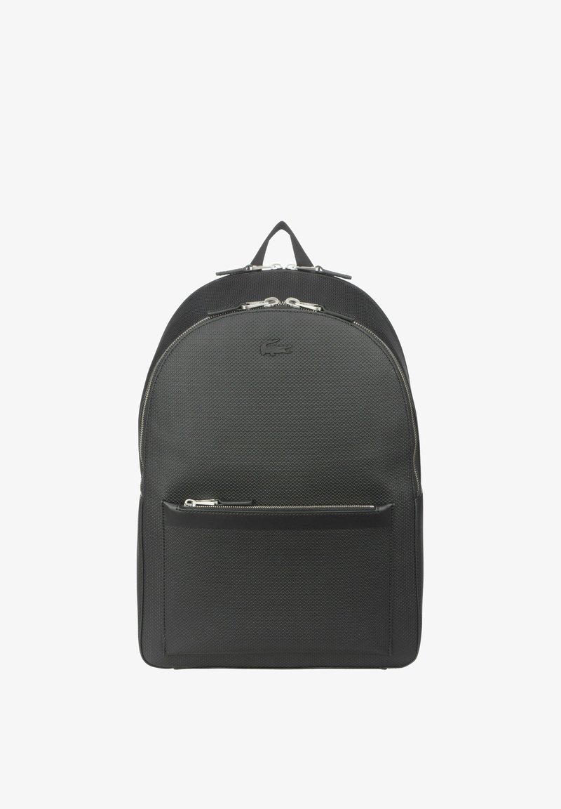 Μαύρο σακίδιο πλάτης με υφή υφάσματος, στρογγυλή κορυφή, διπλούς φερμουάρ, μπροστινή τσέπη και λογότυπο επωνυμίας. Ρυθμιζόμενοι ιμάντες και ανθεκτική λαβή για μεταφορά.