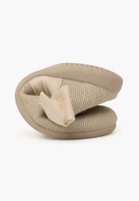 Beige Stoffslipper mit einer strukturierten Oberseite und weichem, gefaltetem Design, ausgestattet mit einer glatten, beigen Sohle. Kompakte und leichte Form.