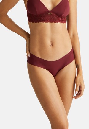 Soutien-gorge bordeaux avec détails en dentelle et garniture dorée, associé à une culotte sans coutures assortie, exhibant un tissu lisse et extensible.
