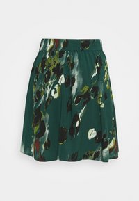 Jupe verte avec imprimé floral abstrait en noir, blanc et olive, avec une ceinture élastique et des plis froncés.