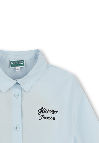 Chemise bleu clair avec un col pointu, à boutons sur le devant, et broderie "Kenzo Paris" en noir sur la poche gauche.