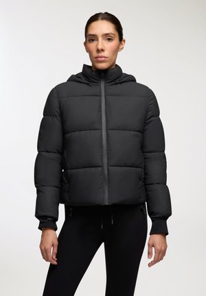 Giacca a vento nera con design crop, cappuccio e chiusura con zip. Presenta cuciture orizzontali e polsini elasticizzati per un maggiore calore.
