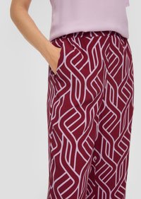 Bordeauxrode broek met een wit geometrisch patroon, voorzien van een elastische tailleband en zijzakken. Zachte stof met een gladde textuur.