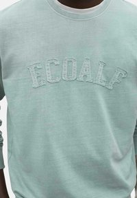 Sudadera de algodón azul claro con la palabra "ECOALF" en letras bordadas en relieve en la parte delantera. Cuello redondo y mangas largas.