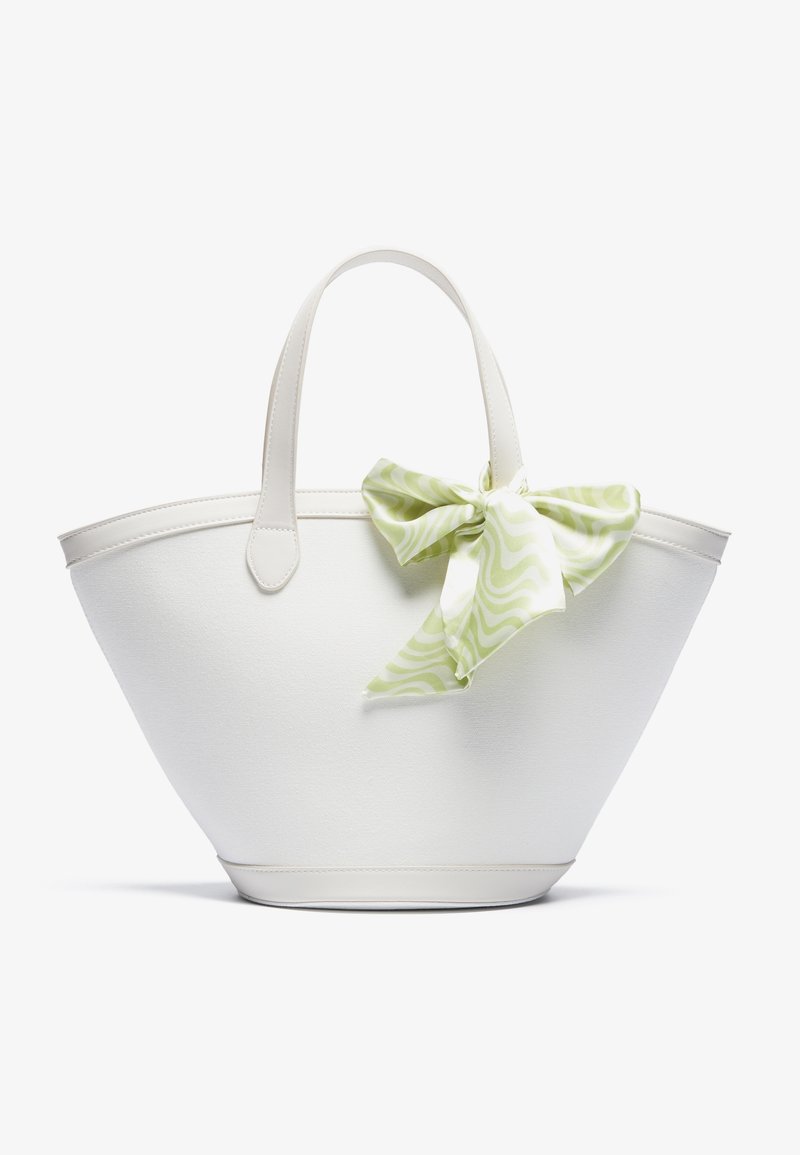 Sac cabas trapézoïdal blanc avec deux poignées, décoré d'un grand nœud vert clair à motifs sur la poignée droite.