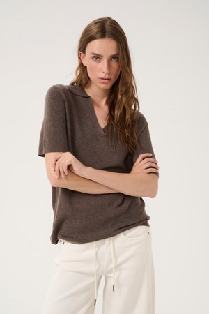 Brown knitted short-sleeve pullover with a V-neckline, paired with off-white drawstring trousers. Smooth texture, casual fit.