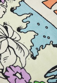 Flerfarget fleece-teppe med blomsterdesign i nyanser av lilla, blått og gult med svarte konturer på en lys bakgrunn.