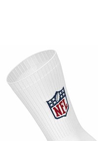 Calzino bianco a coste con risvolto, caratterizzato da un logo NFL ricamato in rosso e blu sul lato. Texture liscia, design atletico.
