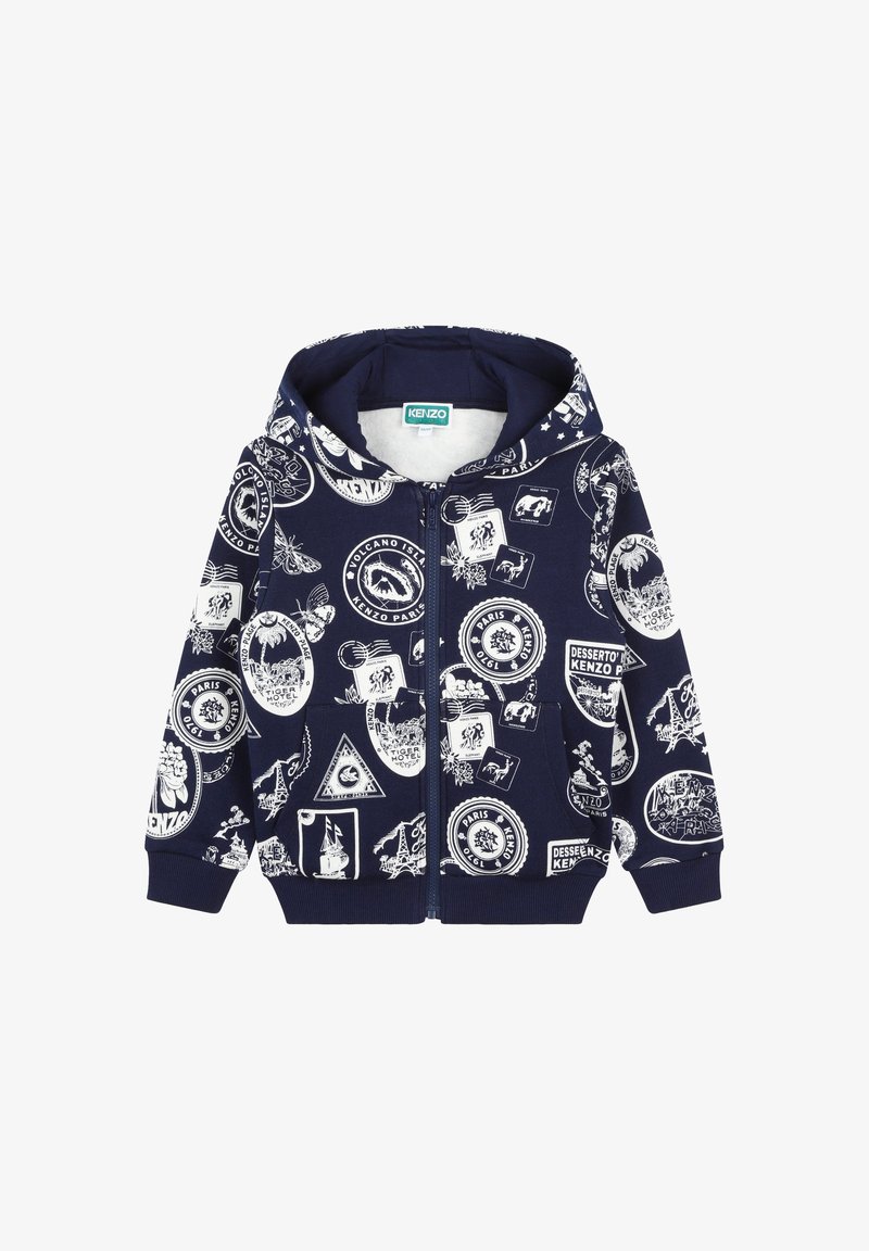 Sweat à capuche zippé bleu marine avec des impressions graphiques blanches représentant divers emblèmes, y compris des animaux et des paysages. Tissu doux, poches avant.