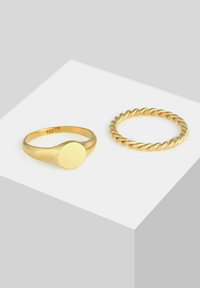 Set de inele cu tonuri de aur, featuring un brățară netedă și rotunjită cu un vârf plat disc și un design de brățară împletită, ambele realizate din argint sterling 925.