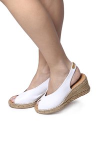 Vita läder wedge sandaler med öppen tå-design, med en vävd jute-klack och en slät, elegant överdel med sidoutskärningar.