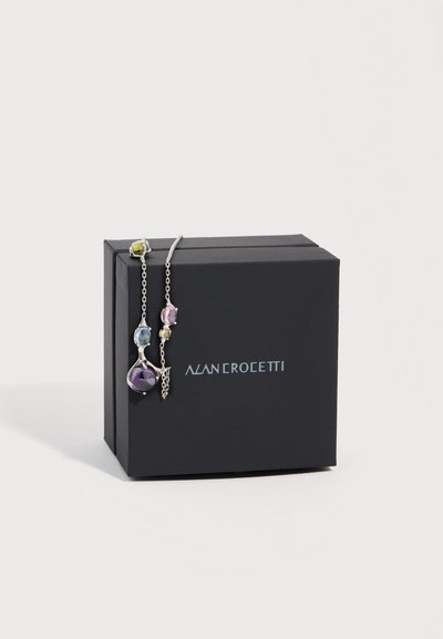 Schwarze Alan Crocetti-Schachtel mit einer silbernen Halskette, die mehrfarbige Edelsteine zeigt und über die Ecke gelegt ist.