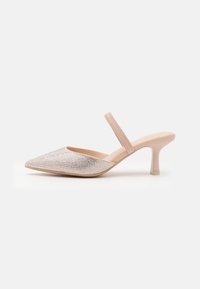 Tacco slingback beige con punta affusolata e tacco stiletto basso, caratterizzato da brillanti embellishments in strass sulla parte anteriore.