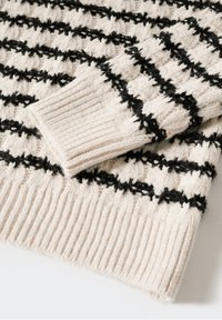 Manche de pull en maille crème pliée sur le corps avec des rayures horizontales noires texturées et des poignets et ourlet côtelés.