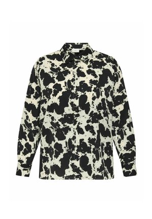 Koszula z długim rękawem o wzorze w czarno-białe krowie plamy, z kołnierzykiem w kształcie ostrego i luźnym kroju.