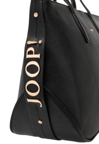 Schwarze Lederhandtasche mit strukturierter Oberfläche, die ein auffälliges goldfarbenes Logo an der Seite und dekorative Metallakzente aufweist.