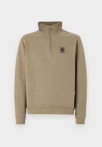 Pull beige à manches longues avec col à demi-fermeture éclair et petit patch logo noir sur la poitrine gauche, design simple.