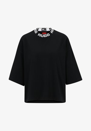 Sort oversized T-shirt lavet af bomuld, med rund halsudskæring og hvidt logo trim. Korte, brede ærmer og en lige kant.