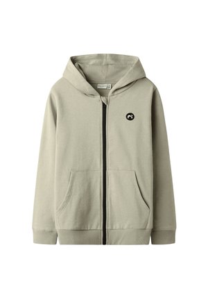 Hellbeiges Kapuzensweatshirt mit durchgehendem Reißverschluss, Fronttaschen, gerippten Bündchen und Bund sowie einem kleinen schwarzen runden Logo auf der Brust.