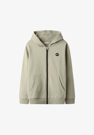 Hellbeiges Kapuzensweatshirt mit durchgehendem Reißverschluss, Fronttaschen, gerippten Bündchen und Bund sowie einem kleinen schwarzen runden Logo auf der Brust.