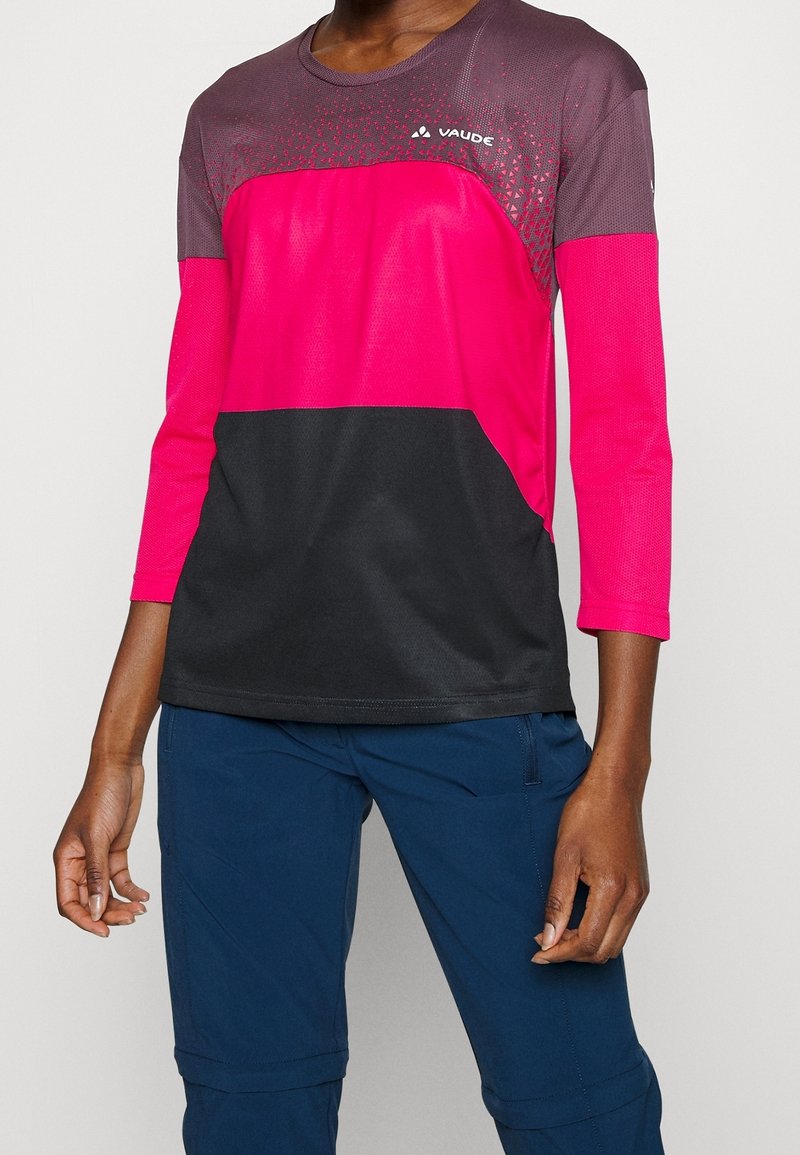 Fuchsia och svart långärmad träningsskjorta gjord av lätt och andningsbart tyg, med rundad halsringning och texturerade accenter.