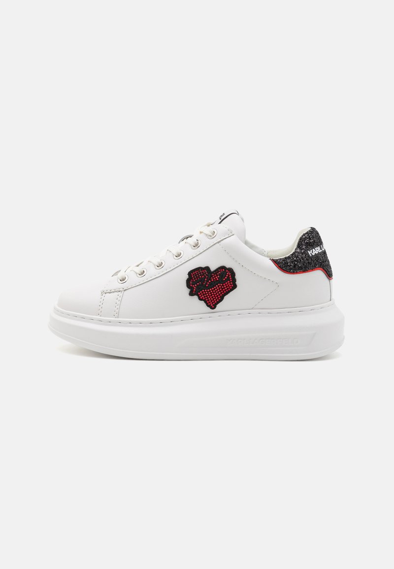 White sneaker with a textured upper, round toe, black and red embroidered heart design, and a chunky white sole. Includes branded heel accents.