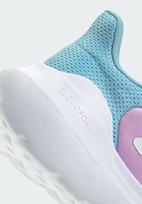 Jasnoniebieski siateczkowy tenis sneaker z białą gumową podeszwą, posiadający fakturowaną górę i fioletowy akcent. Logo Cloudfoam na podeszwie.