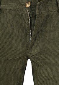 Close-up of olive green corduroy pants with partially unzipped silver zipper and brown button at waistband.