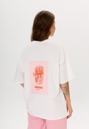 Biała, oversize t-shirt z różowym prostokątnym graficznym wzorem na plecach, z ilustracją pomarańczowej puszki sardynkowej i napisem "SARDYNKI Portugalia."