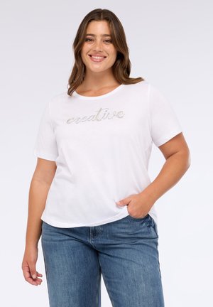 Weißes T-Shirt aus Baumwolle mit kurzen Ärmeln, das "creative" in metallischer Schriftart zeigt. Kombiniert mit blauen Jeans aus Denim. Angenehme Textur, lockere Passform.