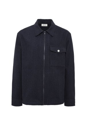 Navy quilted jacket with a front zipper, pointed collar, single chest pocket, and silver button detail. Textured fabric adds dimension.