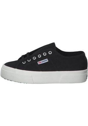 Sneaker in tela nera con design stringato, suola in gomma bianca e grip testurizzato. Presenta occhielli in metallo argentato e un piccolo logo.
