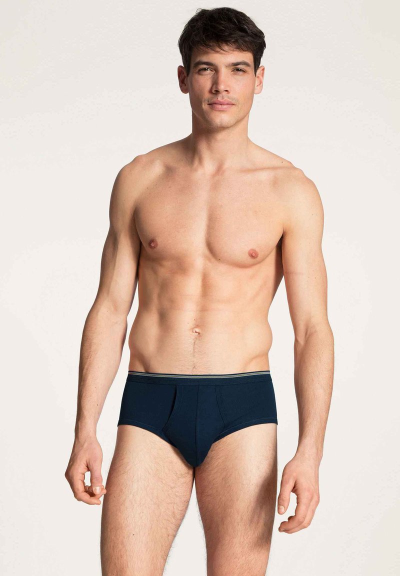 Marineblauwe herenbriefs met een gestructureerde tailleband voorzien van een groene streep. De stof lijkt glad en licht elastisch.