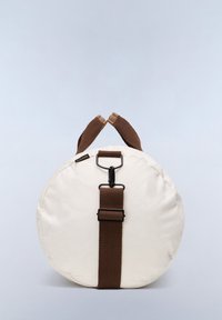 Rund taske i cremefarvet lærred med en brun rem og håndtag, prydet med en sort spænde. Glat tekstur, minimalistisk design.