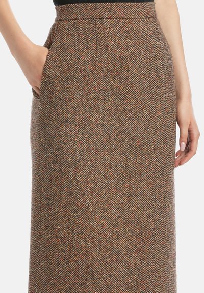 Fustă din tweed în model herringbone, având nuanțe de maro, cu accente de portocaliu și roșu. Include buzunar lateral. Textură netedă.