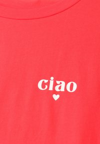Tissu rouge avec texte blanc en minuscules « ciao » et un petit symbole de cœur sous le texte.