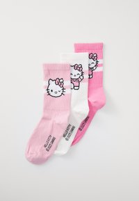 Tre par bomullssockor i rosa och vitt. Har en Hello Kitty-design på varje strumpa, med ribbad textur och kontrasterande ränder.