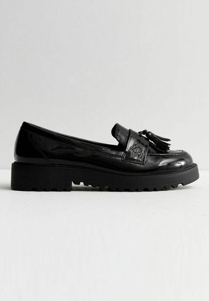 Sorte patentlæder loafers med en kraftig gummisål, der har en dekorativ strop og frynse-detaljer. Glat tekstur og rund form.