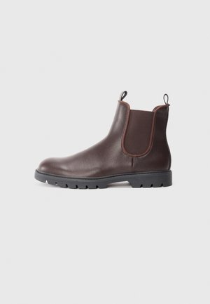Bottine Chelsea en cuir marron avec panneaux élastiques sur les côtés, languette à l'arrière et semelle en caoutchouc dotée d'un motif de semelle améliorant l'adhérence.