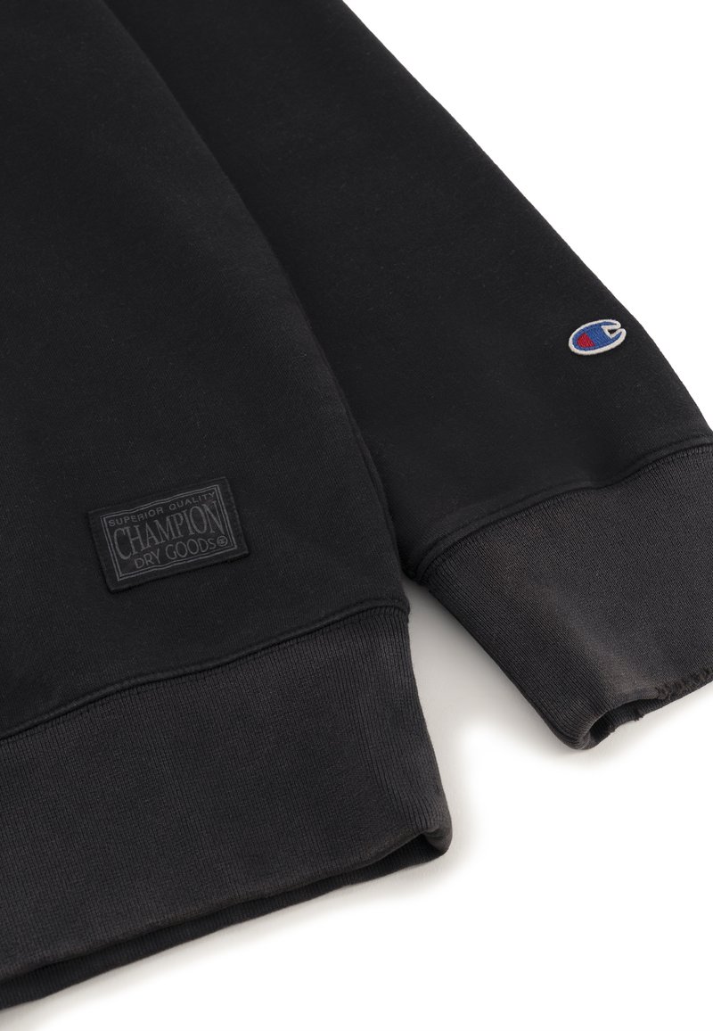 Sweatshirt noir en mélange de coton, avec des poignets et un ourlet côtelés, une étiquette tissée sur le devant et un petit patch logo sur la manche.